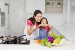 Frau und Kind bereiten Essen zu